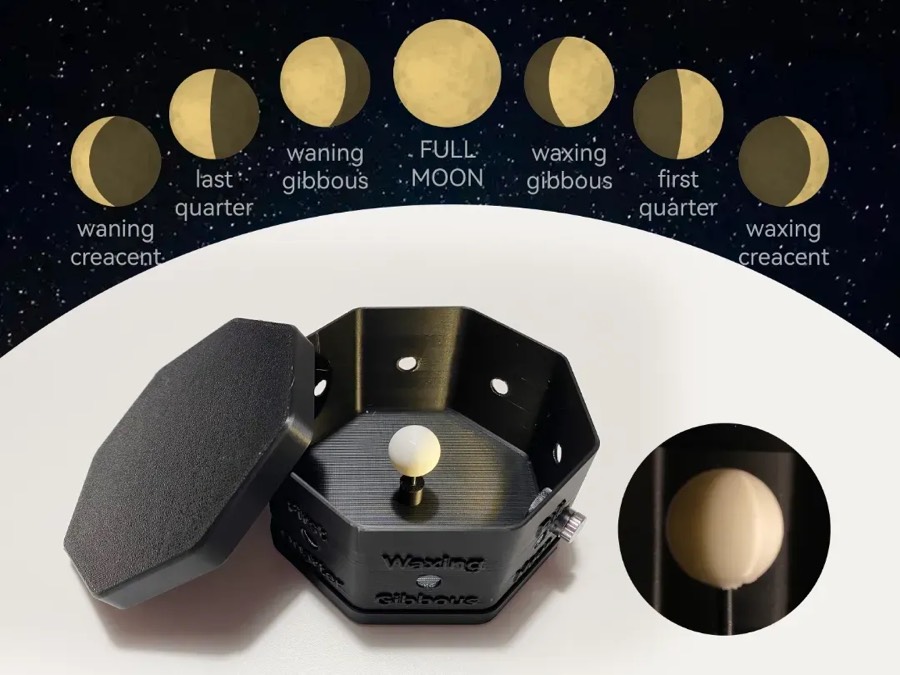Caja octogonal negra abierta con una esfera blanca al centro y las fases de la Luna ilustradas arriba