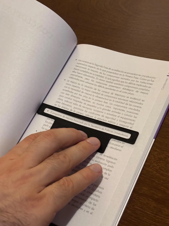 Guía de lectura negra con ventana sobre la página de un libro