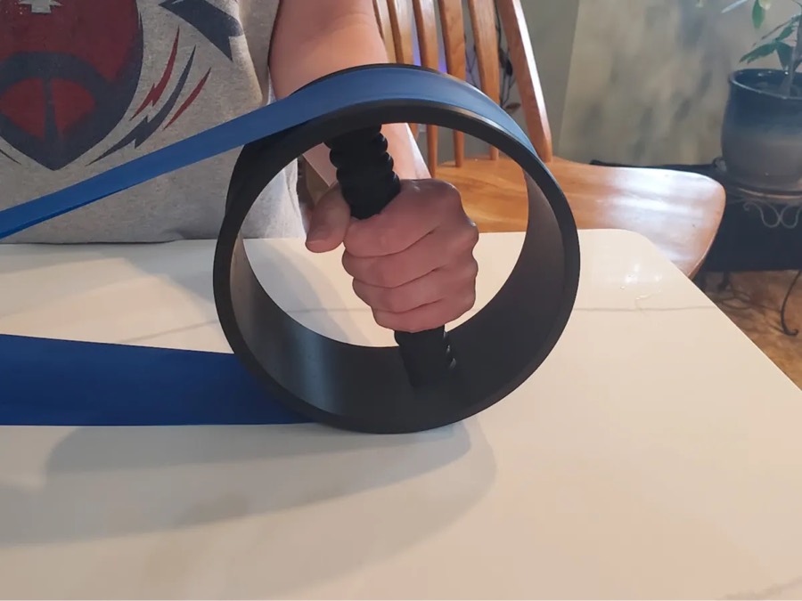 Mano girando la rueda de rotación de antebrazo con una banda elástica azul