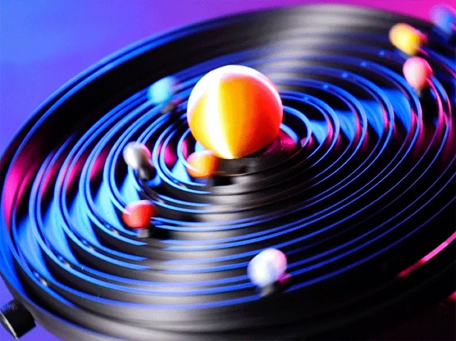 Maqueta del sistema solar con el Sol al centro y planetas sobre pistas circulares negras